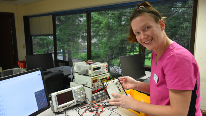 Student holding a microelectronics board