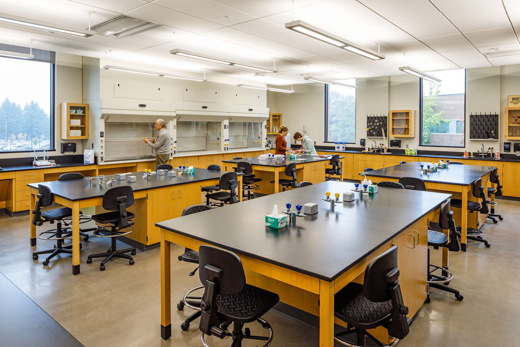 A chemistry lab with a few students inside studying A chemistry lab with a few students inside studying