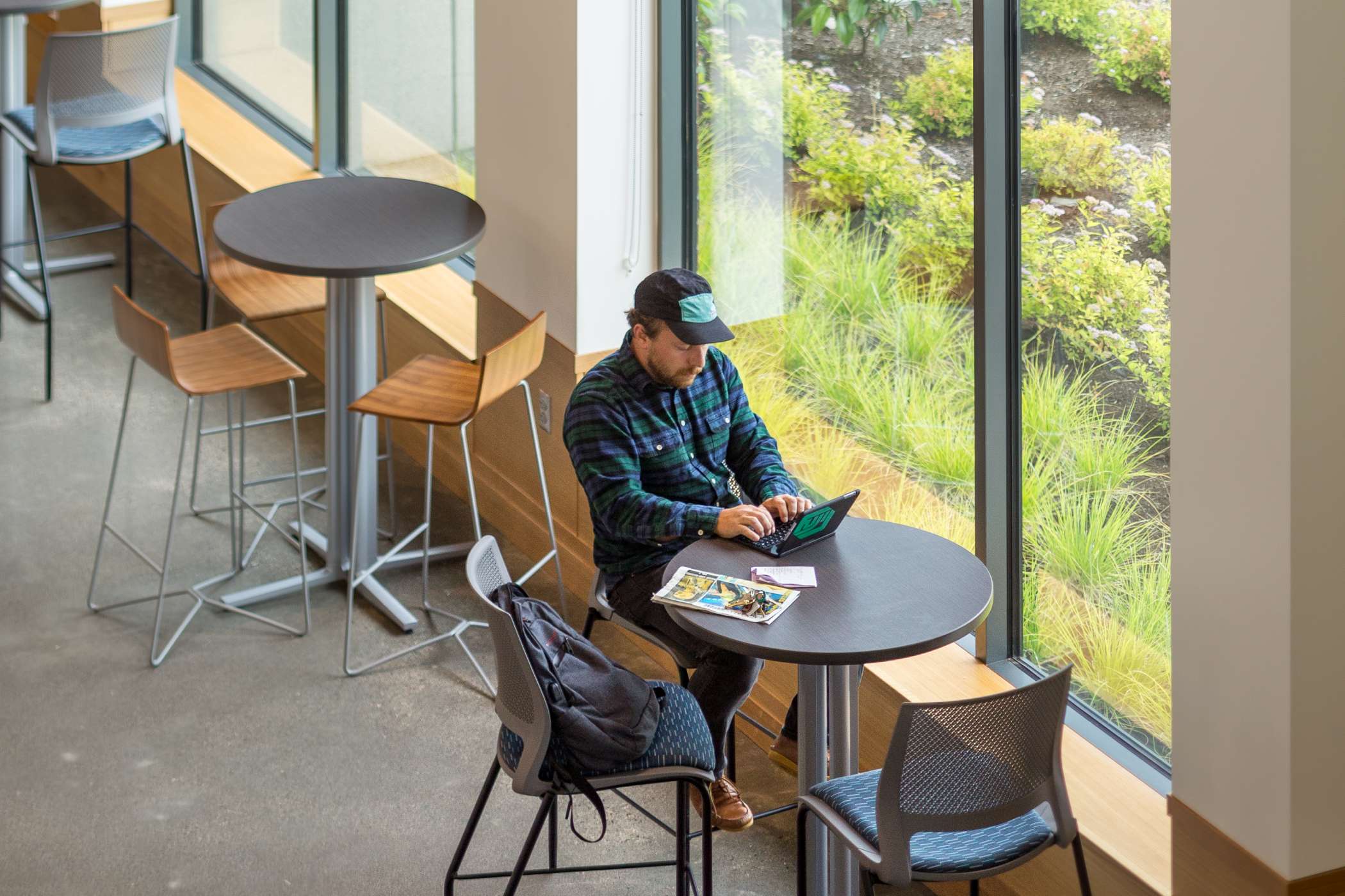 Student studying on laptop at tall table in Harmony West's lounge