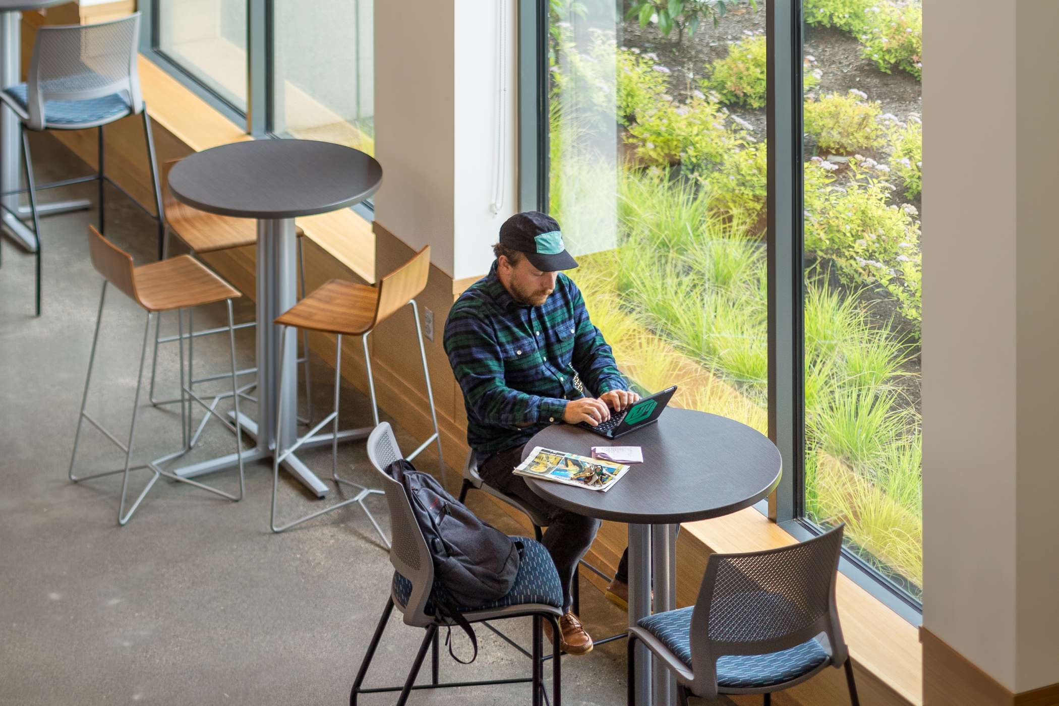 Student studying on laptop at tall table in Harmony West's lounge Student studying on laptop at tall table in Harmony West's lounge