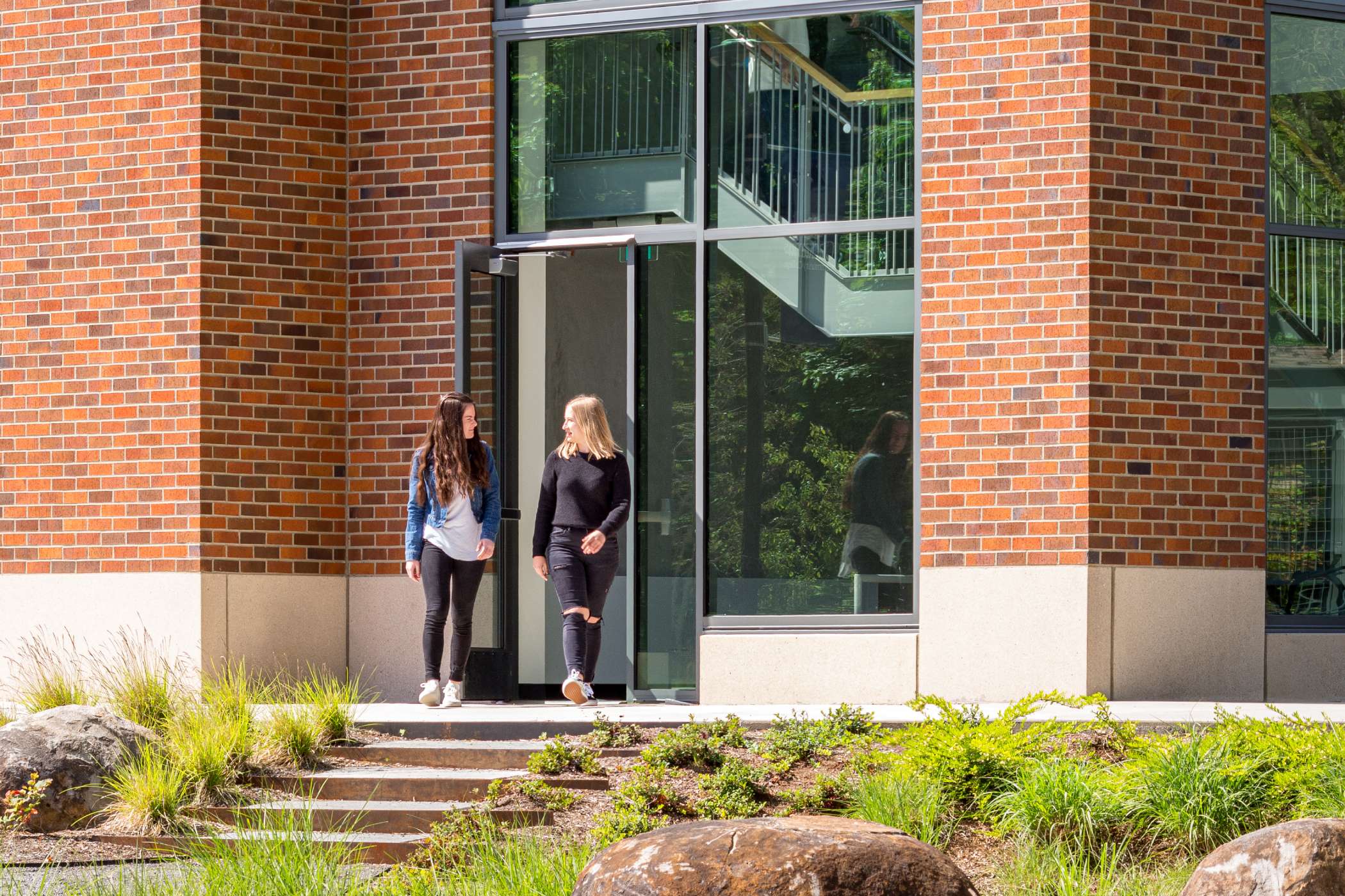 Two students talking and leaving the Harmony West building Two students talking and leaving the Harmony West building