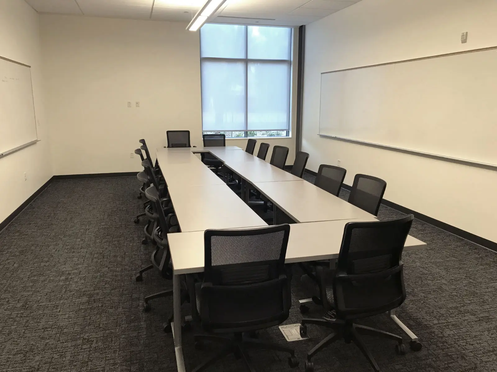 Two rows of chairs and tables in a large Harmony campus conference room