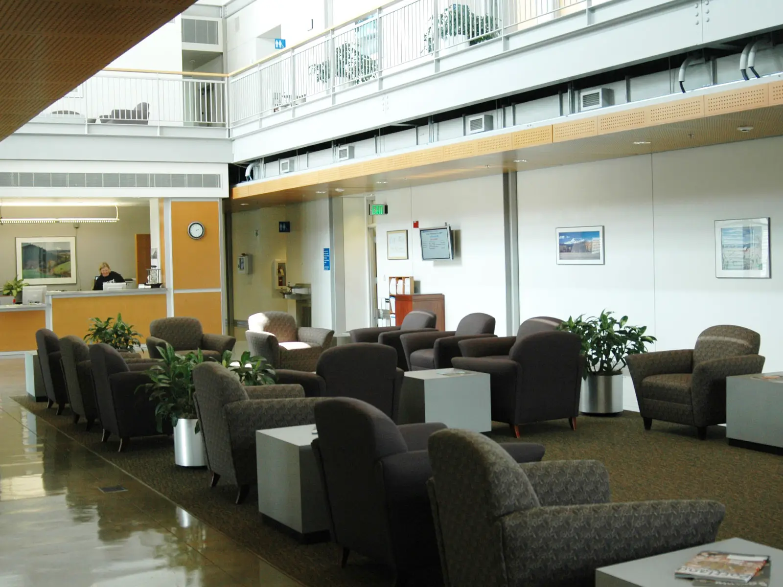 Displays, the front desk and rows of chairs in the lobby and commons gallery of the Wilsonville campus