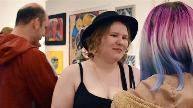 Two people talking at an art exhibition