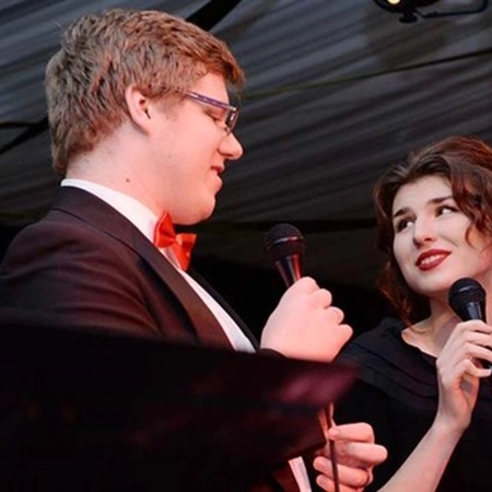 Two people singing at a music performance
