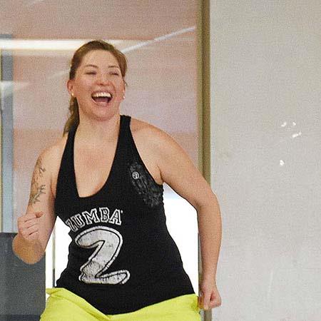 woman exercises wearing shirt that says "zumba"