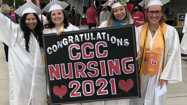 Nursing graduates holding congrats sign