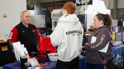 CTE showcase - NEWS Two CTE Showcase attendees talking to an automotive instructor