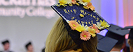 graduating student with mortarboard that reads "keep moving forward"