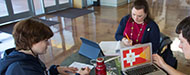 Three students working around a table